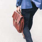 A man carries a briefcase at his side.