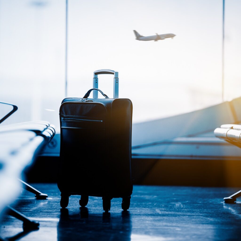 airport waiting area with suitcase and plane in background