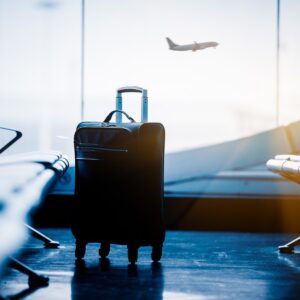 airport waiting area with suitcase and plane in background