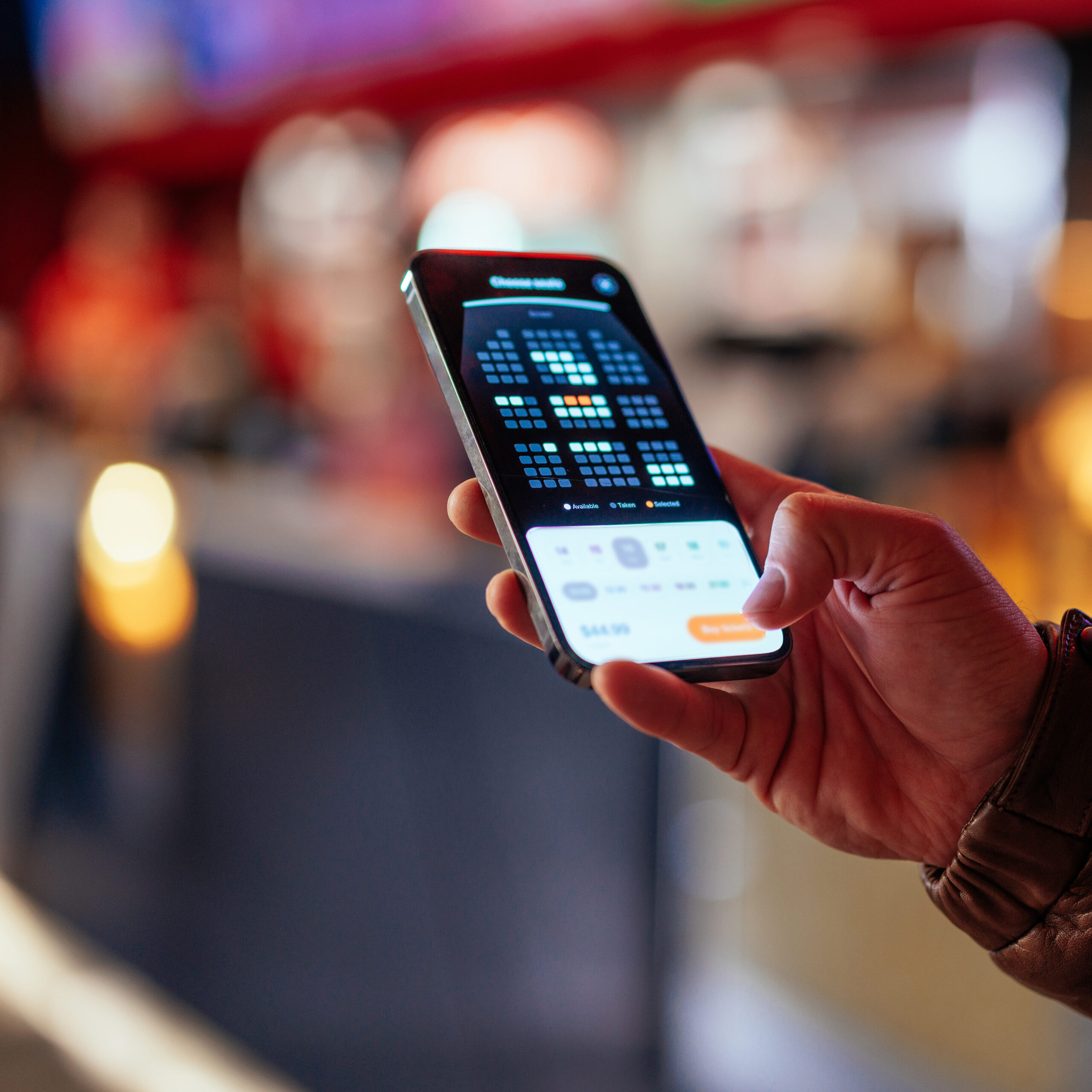 Man using mobile app for booking seats in theater.